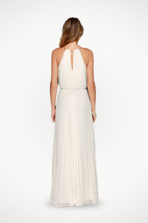 Back view of a woman wearing a white sleeveless belted maxi pleated dress with a keyhole neck detail