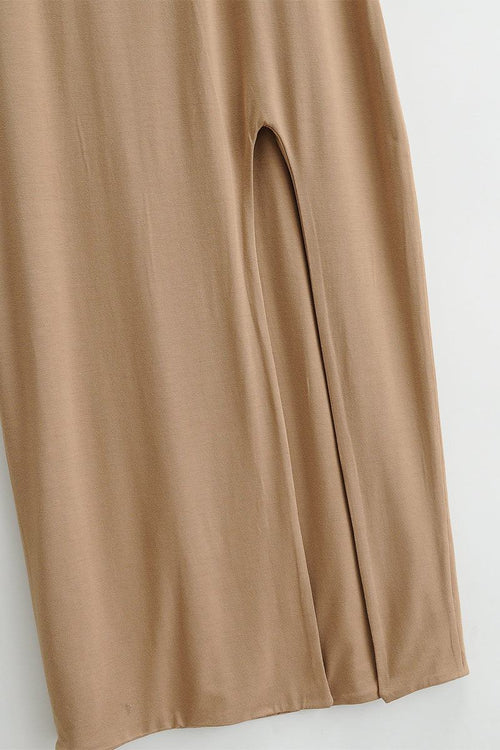 Close-up of beige elegant side slit midi dress fabric and slit detail
