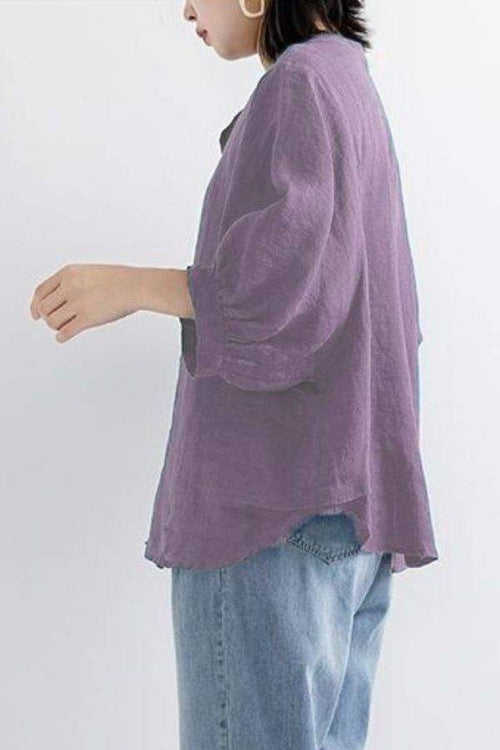 Relaxed loose breathable linen blouse in purple worn with jeans, side view