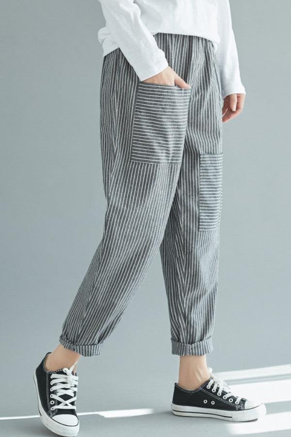 Woman wearing high waist striped comfort pants with patch pockets and rolled cuffs paired with black sneakers
