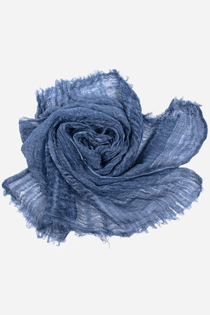 Blue lightweight linen scarf with frayed edges, soft breathable fabric, rolled styling, ideal for versatile wear and travel.