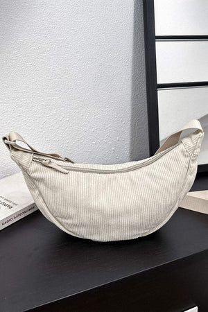 Beige corduroy shoulder bag with adjustable strap and zip closure, soft ridged texture, lightweight and roomy design.