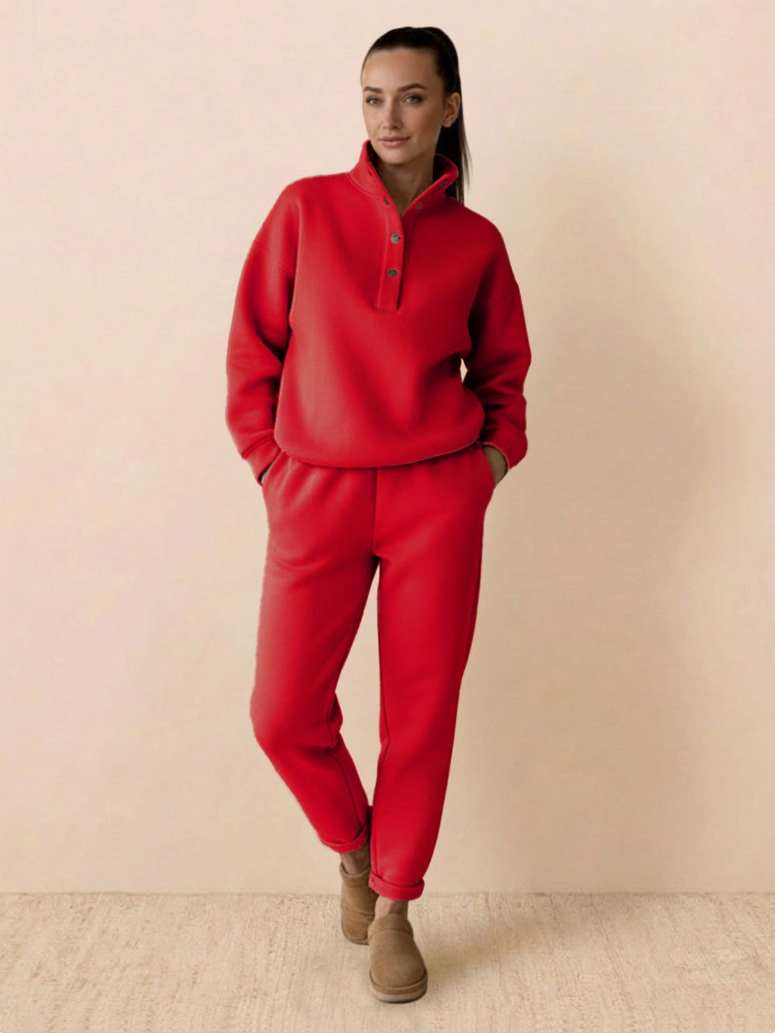 Woman wearing warm and easy two-piece set in red with relaxed fit and button-collar pullover hoodie and matching pants