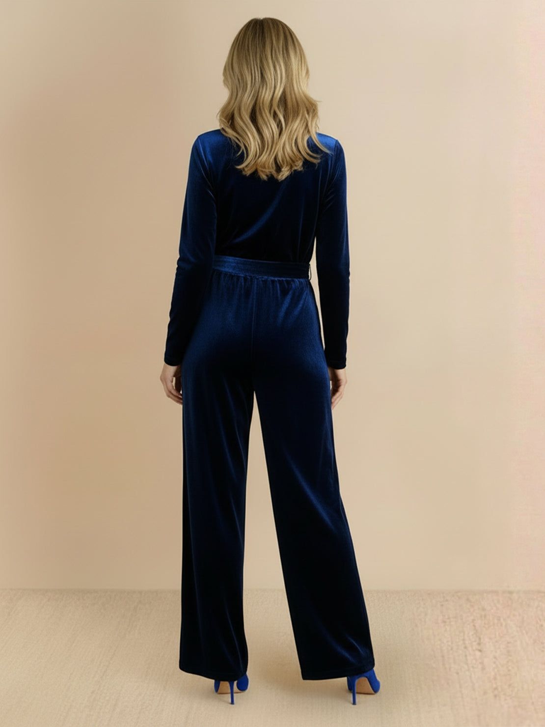 Woman wearing deep V-neck velvet suit with long sleeves and wide-leg pants