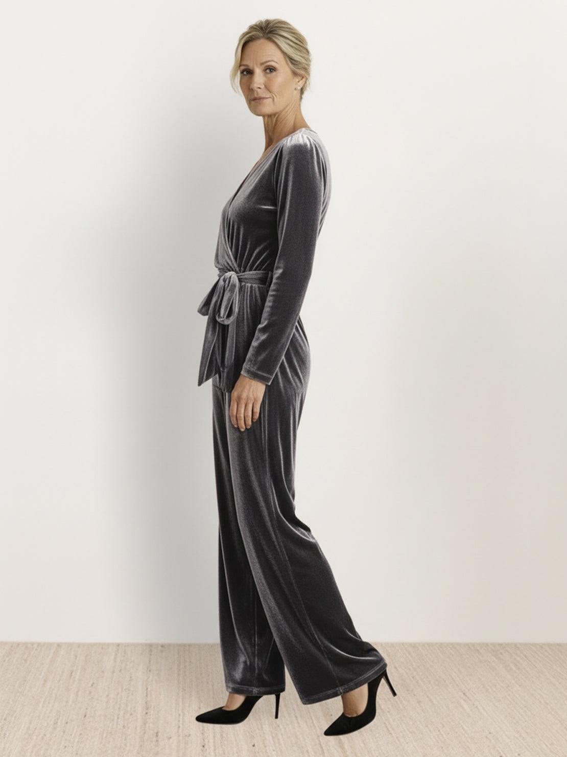 Woman wearing deep V-neck velvet suit with long sleeves and wide-leg pants