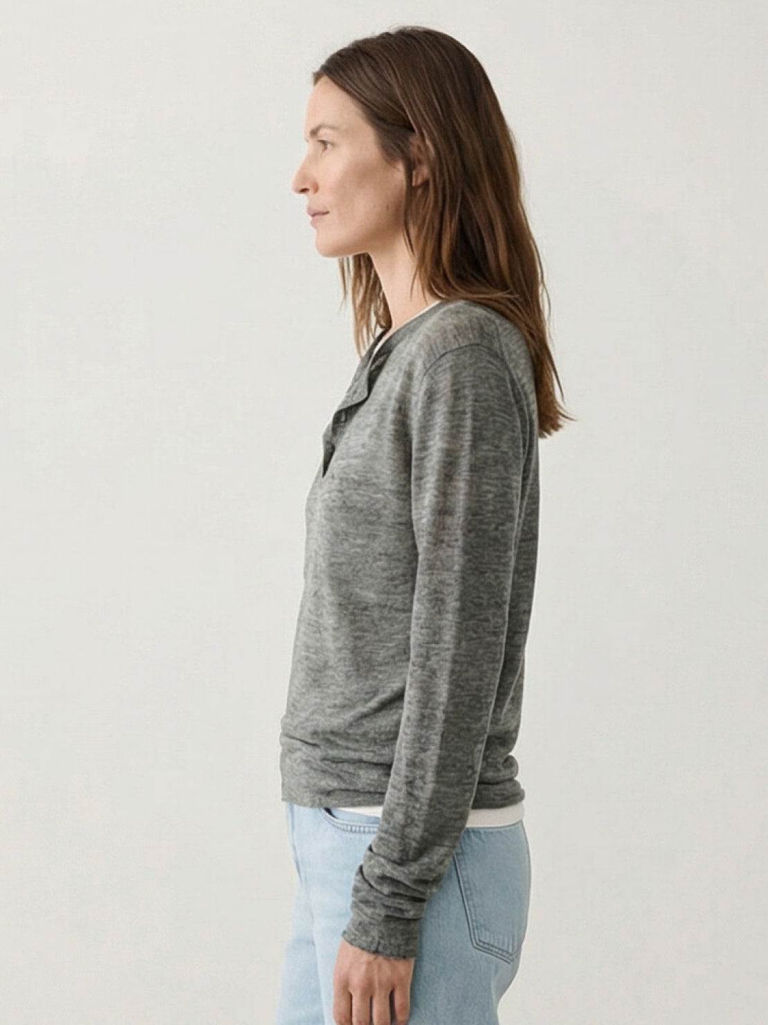 Organic linen henley top with fine knit, relaxed fit, 3-button placket, long sleeves, and side slits.