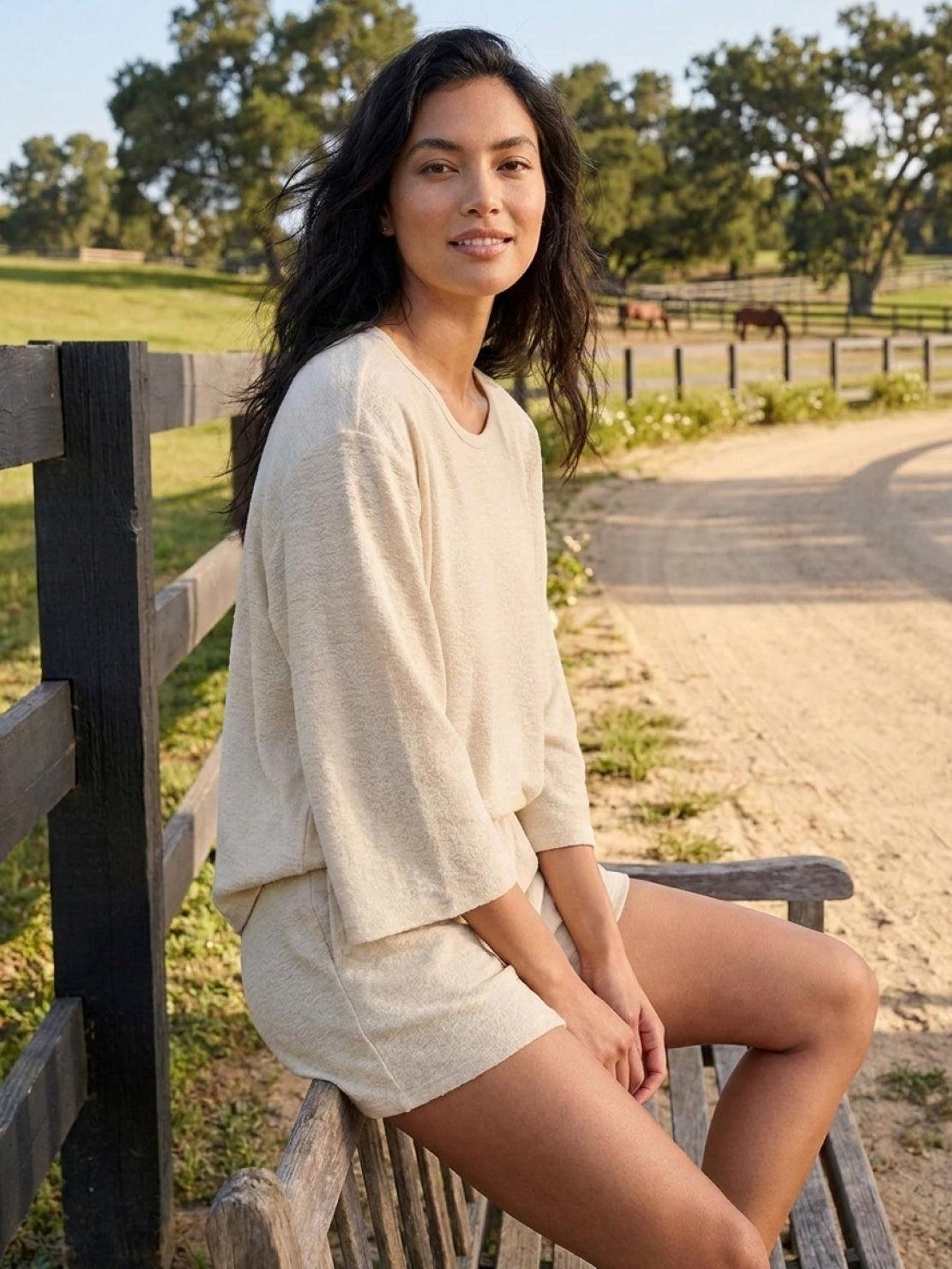 Woman wearing light blue linen blend lounge set with cropped top and shorts in relaxed fit