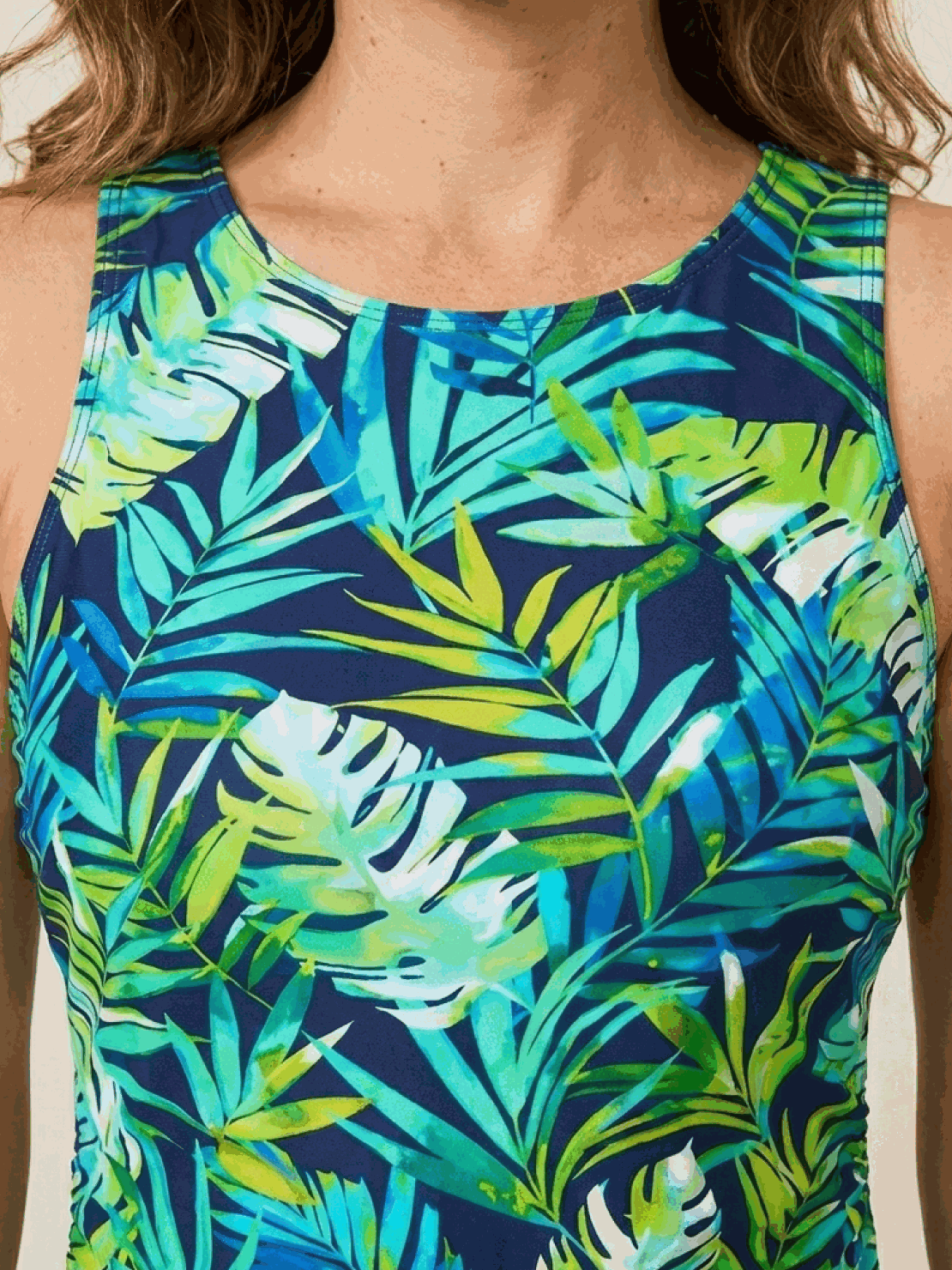 woman wearing high-neck ruched tankini set with printed top and solid swim skirt at the beach