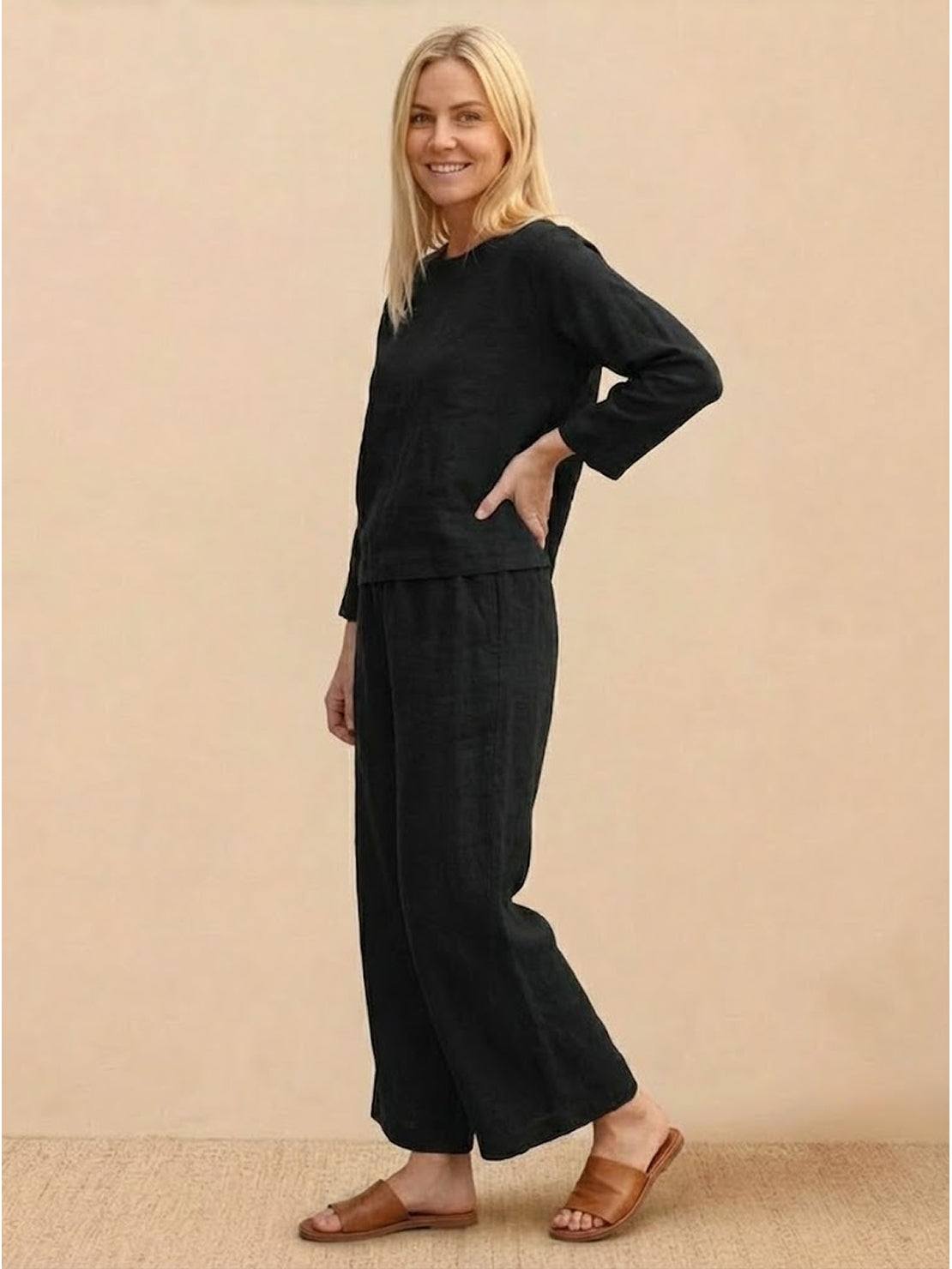 woman wearing loose solid color two-piece set with round-neck top and wide-leg pants standing outdoors