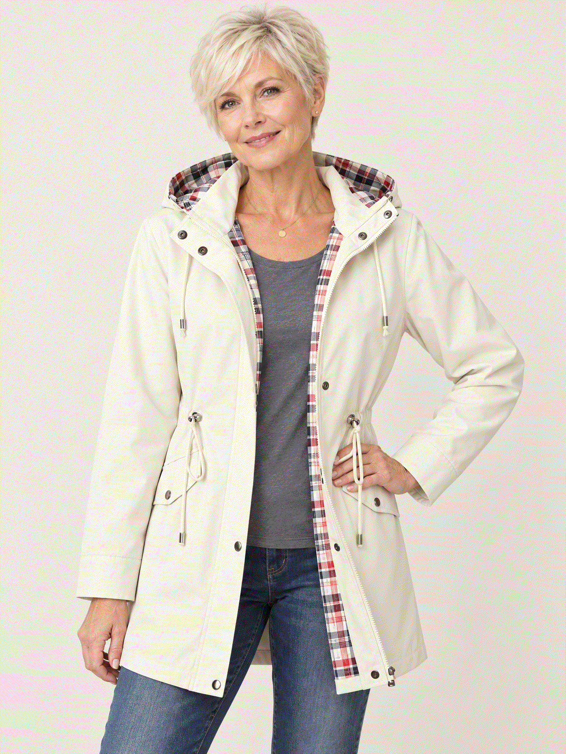 woman wearing plaid-lined hooded rain jacket with snap pockets and drawstring waist outdoors