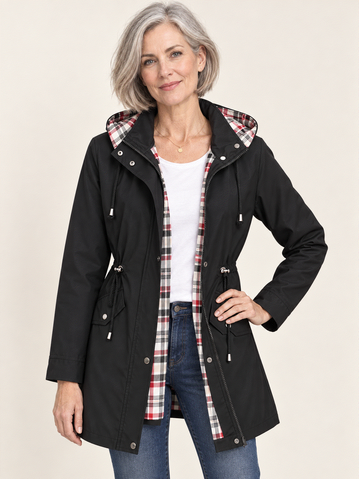 woman wearing a plaid-lined hooded rain jacket with waterproof shell and drawstring waist