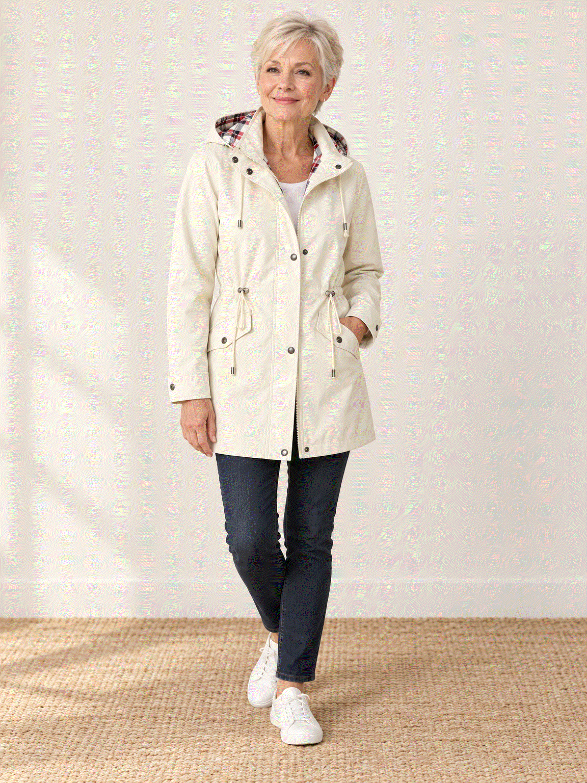 woman wearing plaid-lined hooded rain jacket with red and cream tartan lining on hood and cuffs