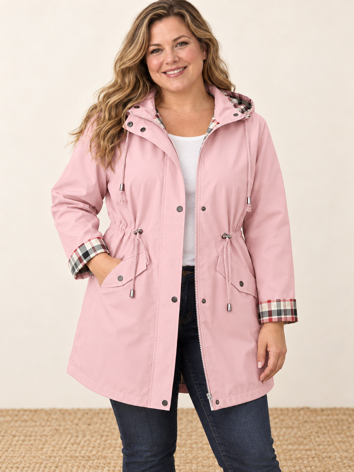 woman wearing a plaid-lined hooded rain jacket standing outdoors in rainy weather