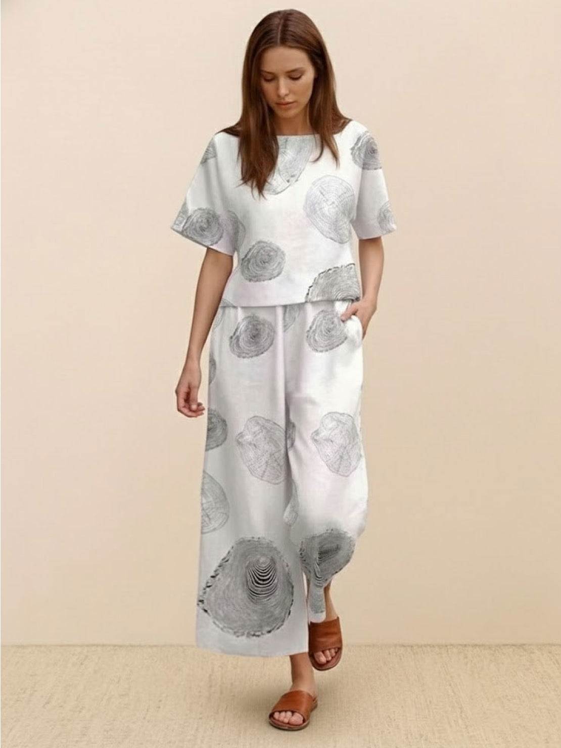 Woman wearing loose fit co-ord set with floral print, wide-leg trousers, and relaxed short-sleeve top.