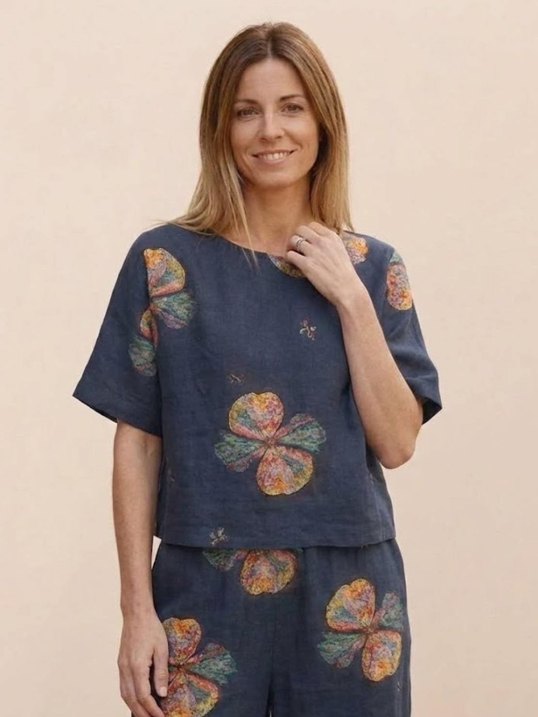 Woman wearing a floral print loose fit co-ord set with wide short sleeves and wide-leg bottoms
