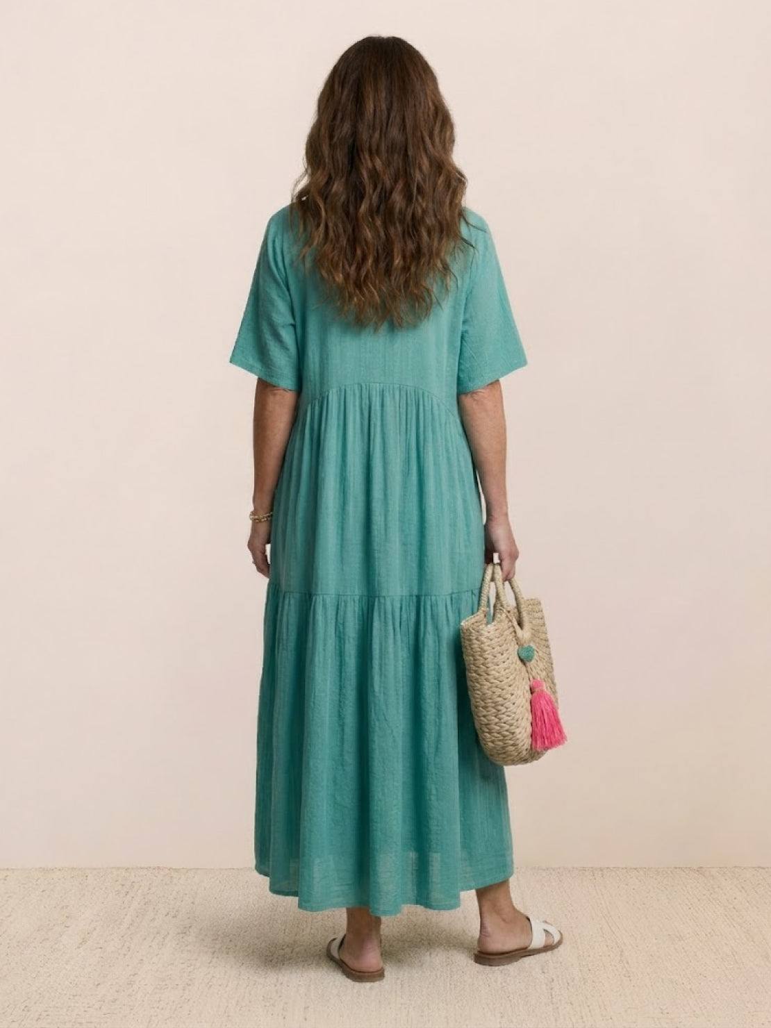 Woman wearing V-neck two-tiered maxi swing dress with flowy tiers and irregular hemline in solid color