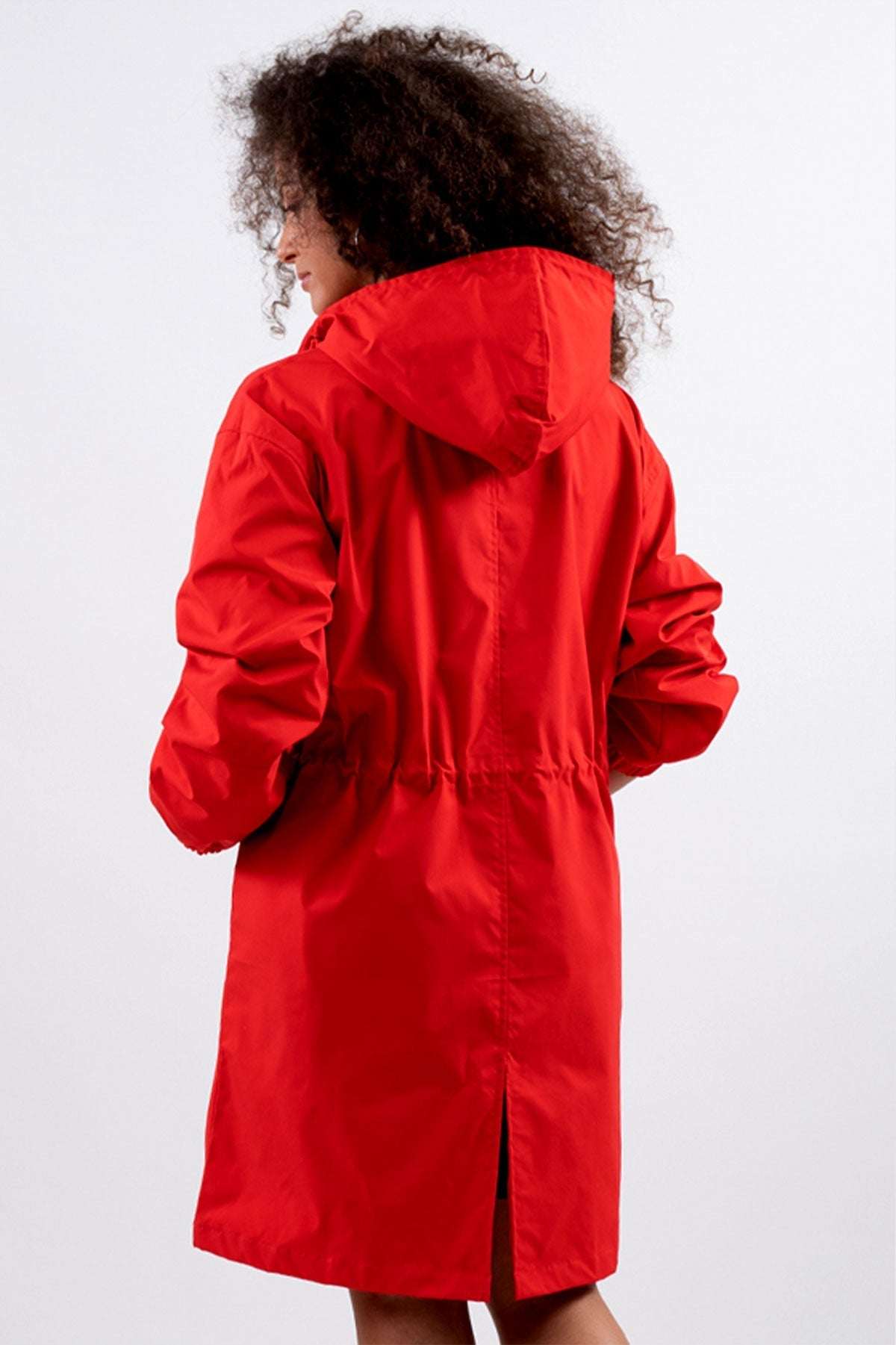 Back view of a model wearing a red Rain Couture Windbreaker, oversized fit, with hood and water-resistant fabric.