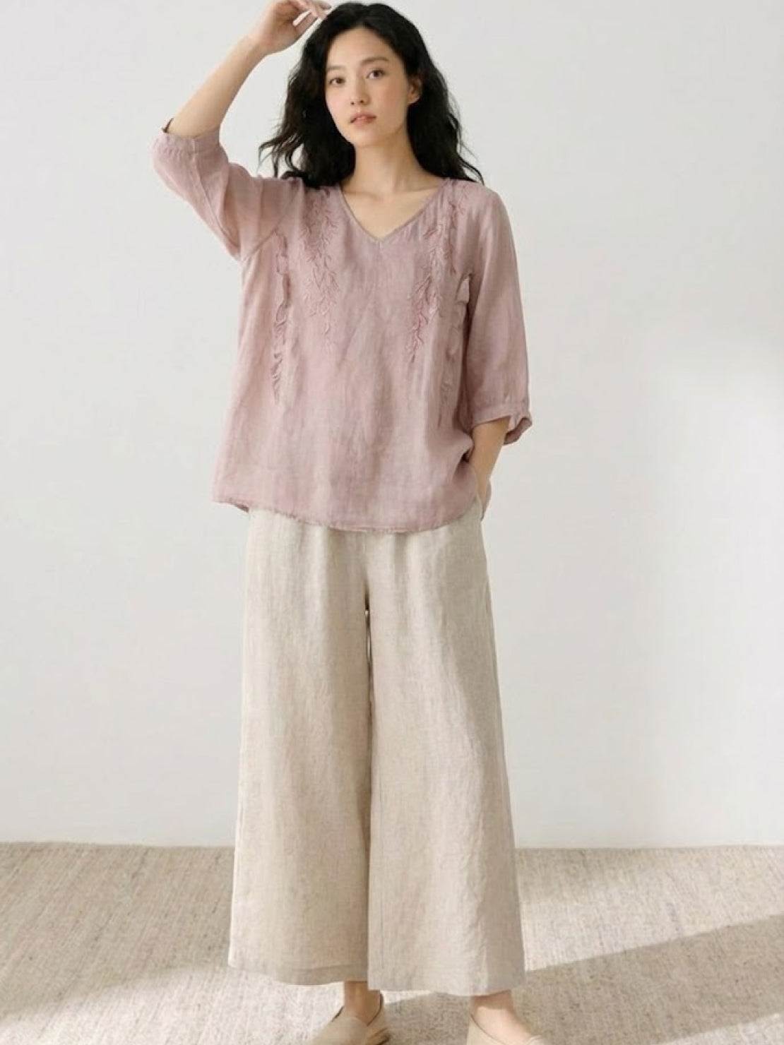 Woman wearing 100% cotton linen blend golden hour set with embroidered V-neck top and wide-leg trousers, styled for summer elegance and comfort