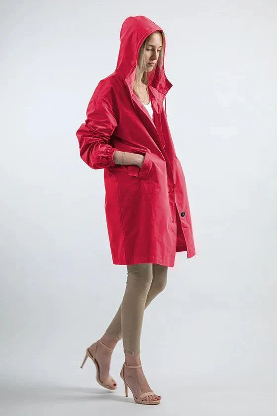 Woman wearing red Rain Couture Windbreaker oversized water-resistant rain jacket with hood and pockets