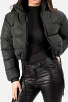 Black sleek cropped puffer jacket with high collar and drawstring hem, styled with black top and leather pants