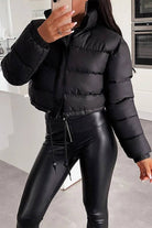 Black sleek cropped puffer jacket paired with black leather pants, stylish winter outerwear