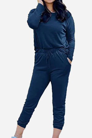 Woman wearing navy blue Cozy Chic Two-Piece Sweatsuit set with long sleeves and high-waisted pants with pockets.