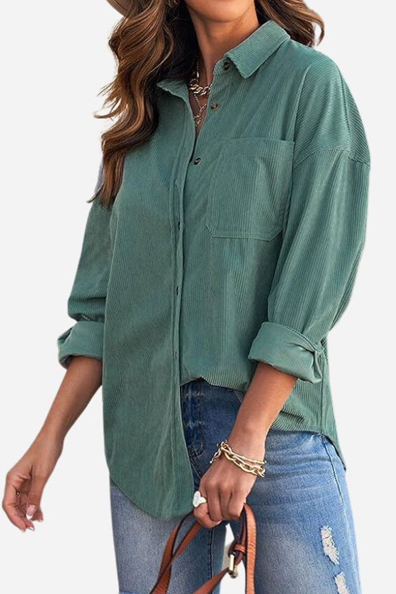 woman wearing sleek suede oversized button-down shirt in green with rolled cuffs and ripped blue jeans