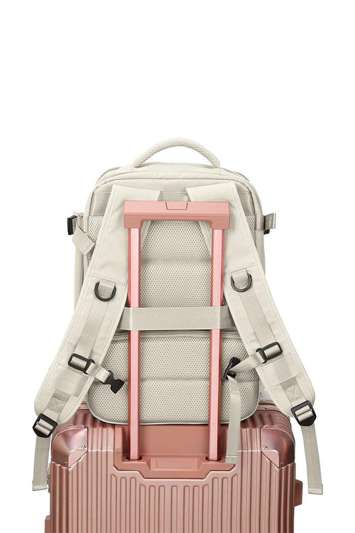 Chic Wanderlust Waterproof Backpack shown attached to a pink rolling suitcase handle, highlighting ergonomic back and adjustable straps.