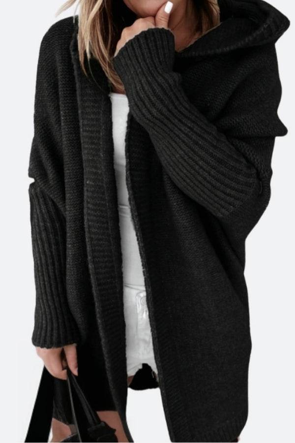 Black warm oversized hooded cardigan with ribbed sleeves and relaxed fit worn over white outfit