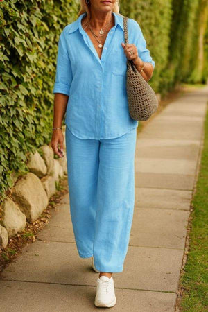 Woman wearing light blue relaxed shirt and trousers two-piece set with white sneakers outdoors