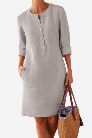 Lightweight gray cotton dress with ¾ rolled sleeves, front buttons, and practical pockets.