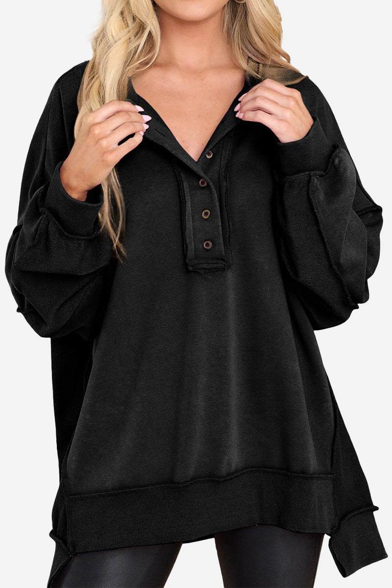 Black oversized urban sweatshirt with slouchy sleeves and buttoned Henley neckline worn by woman