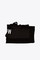 Folded black waterproof travel bag with sturdy handles and minimalist design
