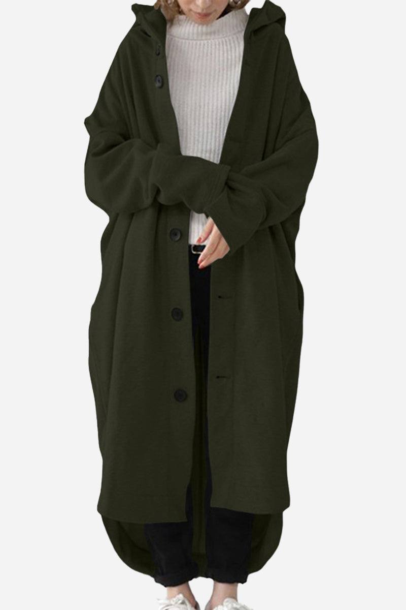 Woman wearing oversized everyday buttoned hooded coat in dark green over casual outfit