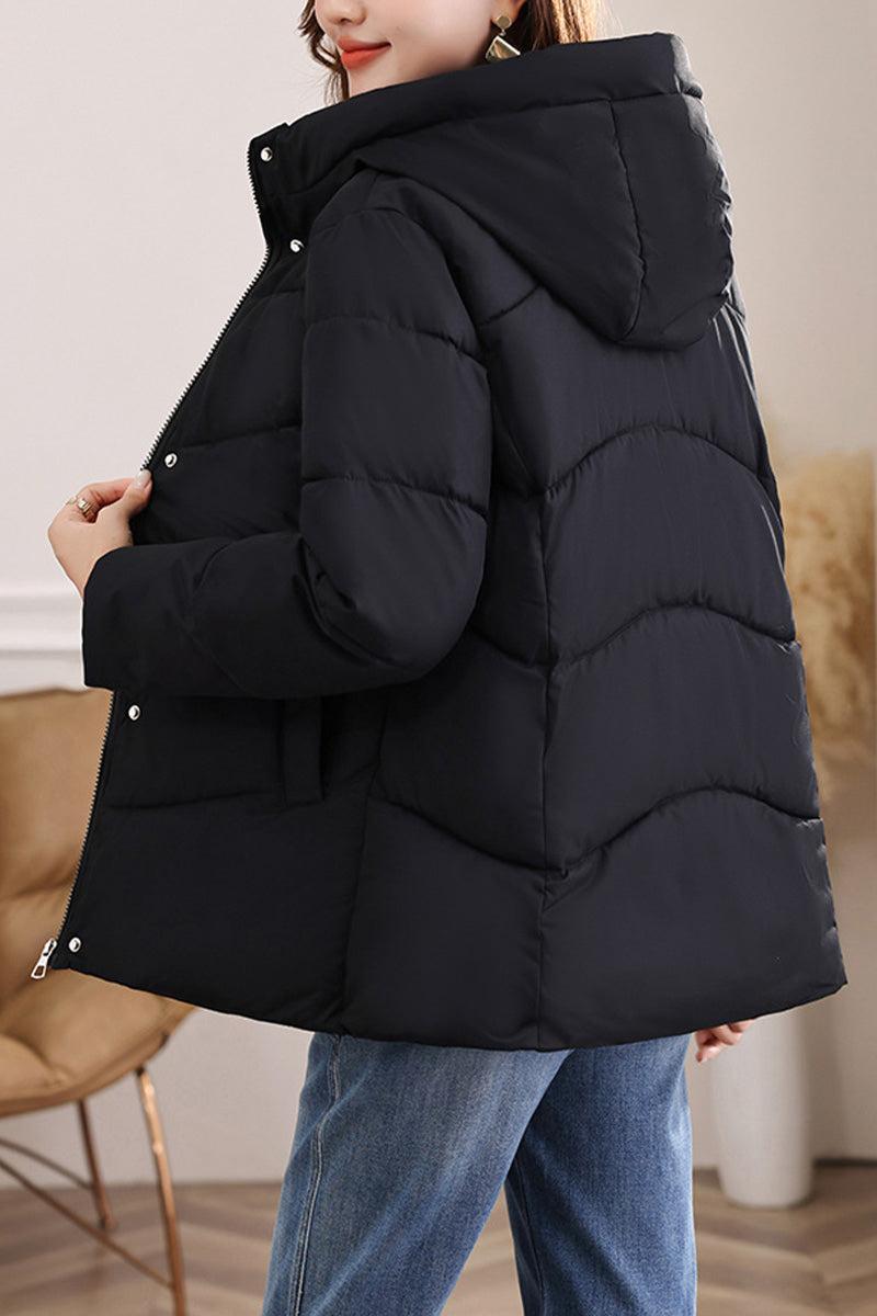 Black mid-length Everyday Warmth Coat with hood and 5-layer thermal insulation, styled with jeans for casual winter wear.
