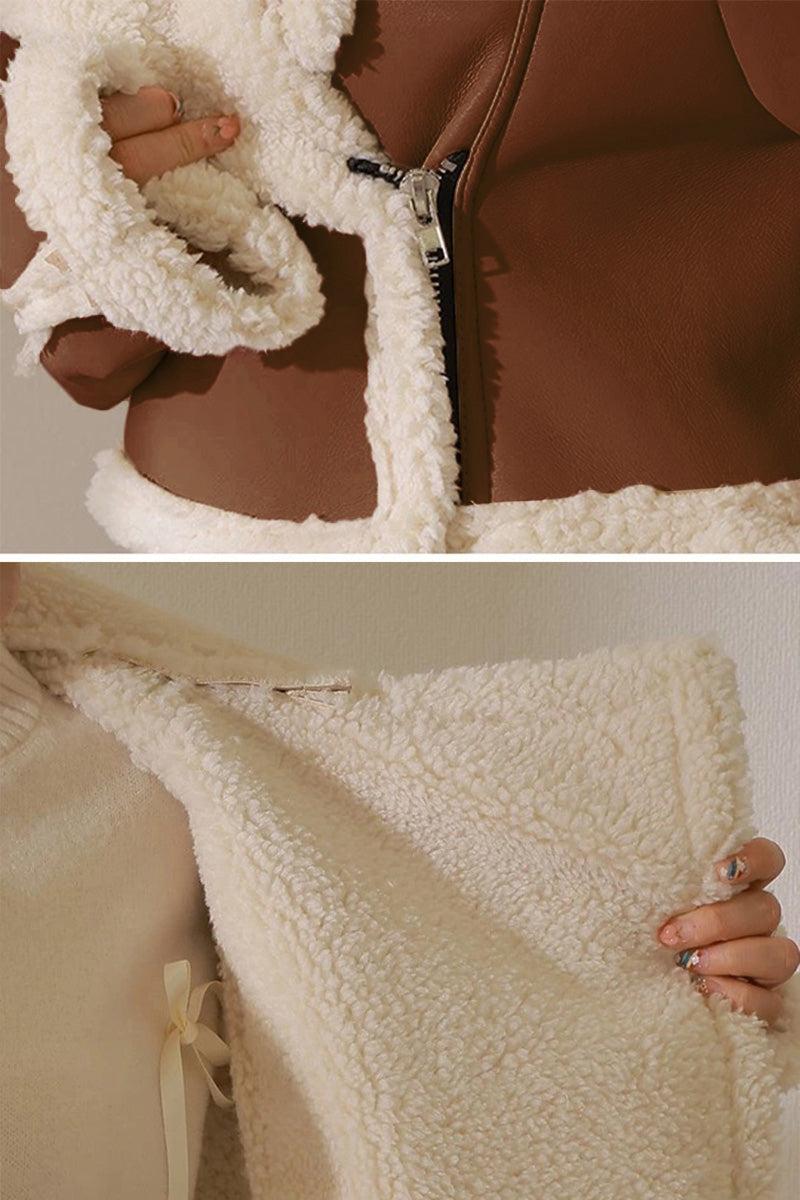 Cropped faux leather jacket with soft cream sherpa lining and trim, warm and wind-resistant design.