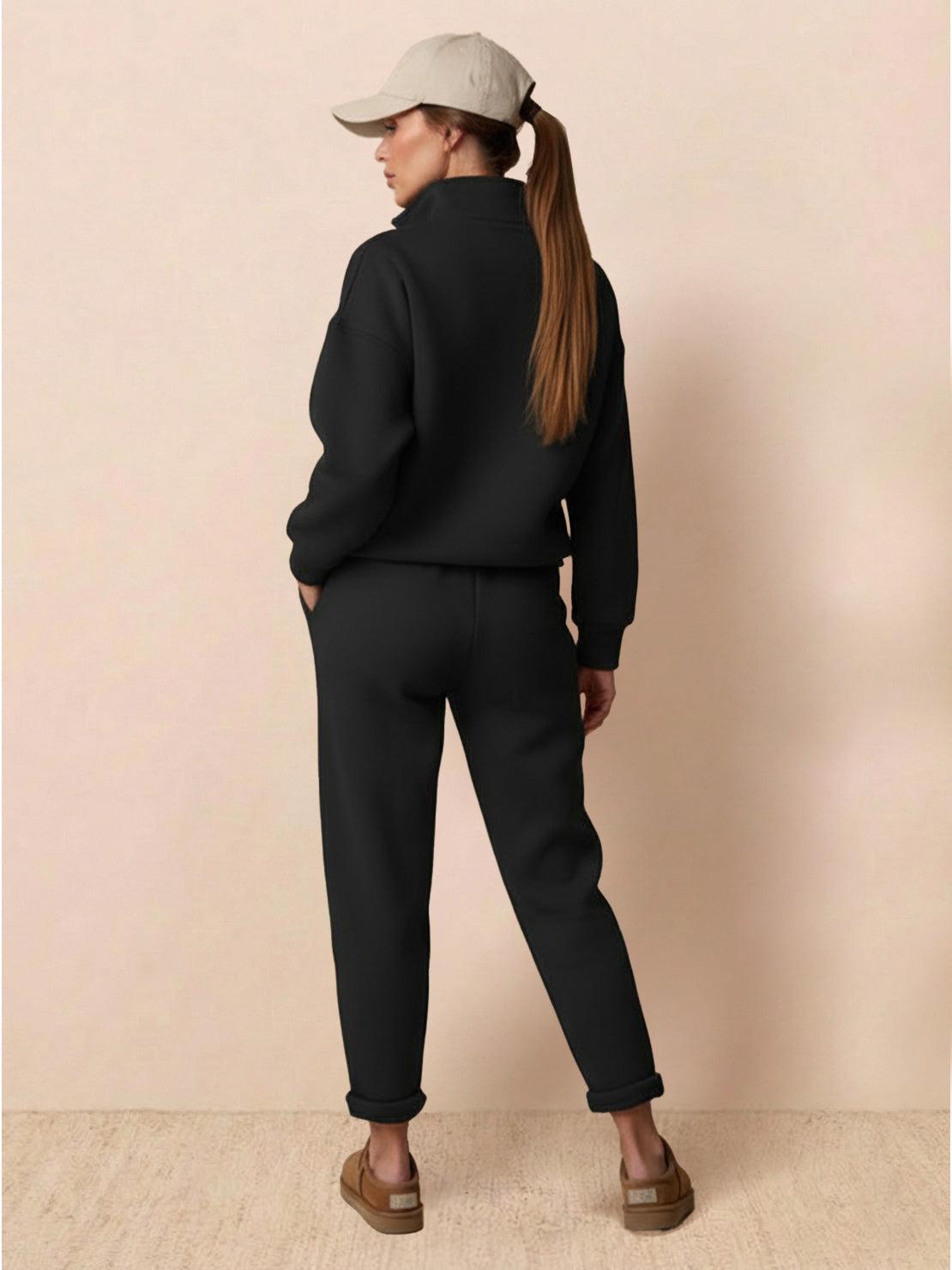 Woman wearing black Warm & Easy Two-Piece Set with relaxed fit, pullover hoodie, and matching pants against beige background
