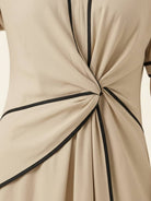 Woman wearing a knot-waist maxi dress with V-neckline and flowing skirt