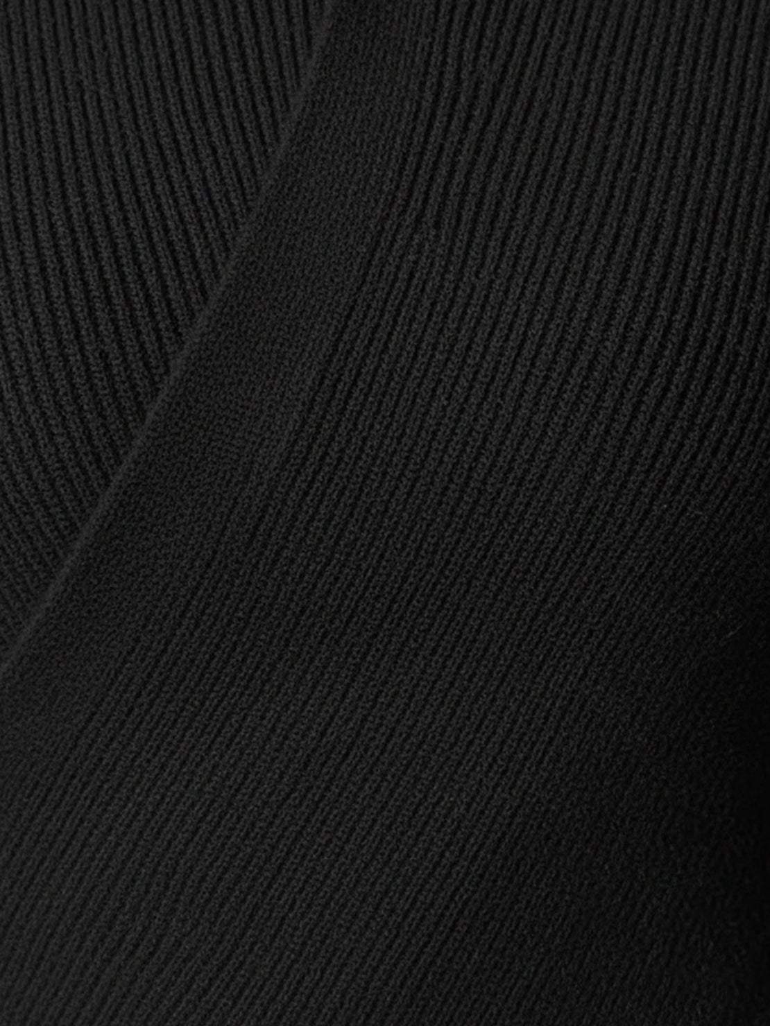 Close-up of slim fit asymmetric wrap ribbed knit top with diagonal button closure and flared cuffs
