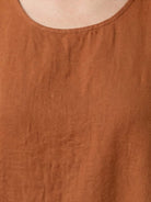 Woman wearing a 100% cotton linen sleeveless maxi dress with round neckline and flowing ankle-length silhouette