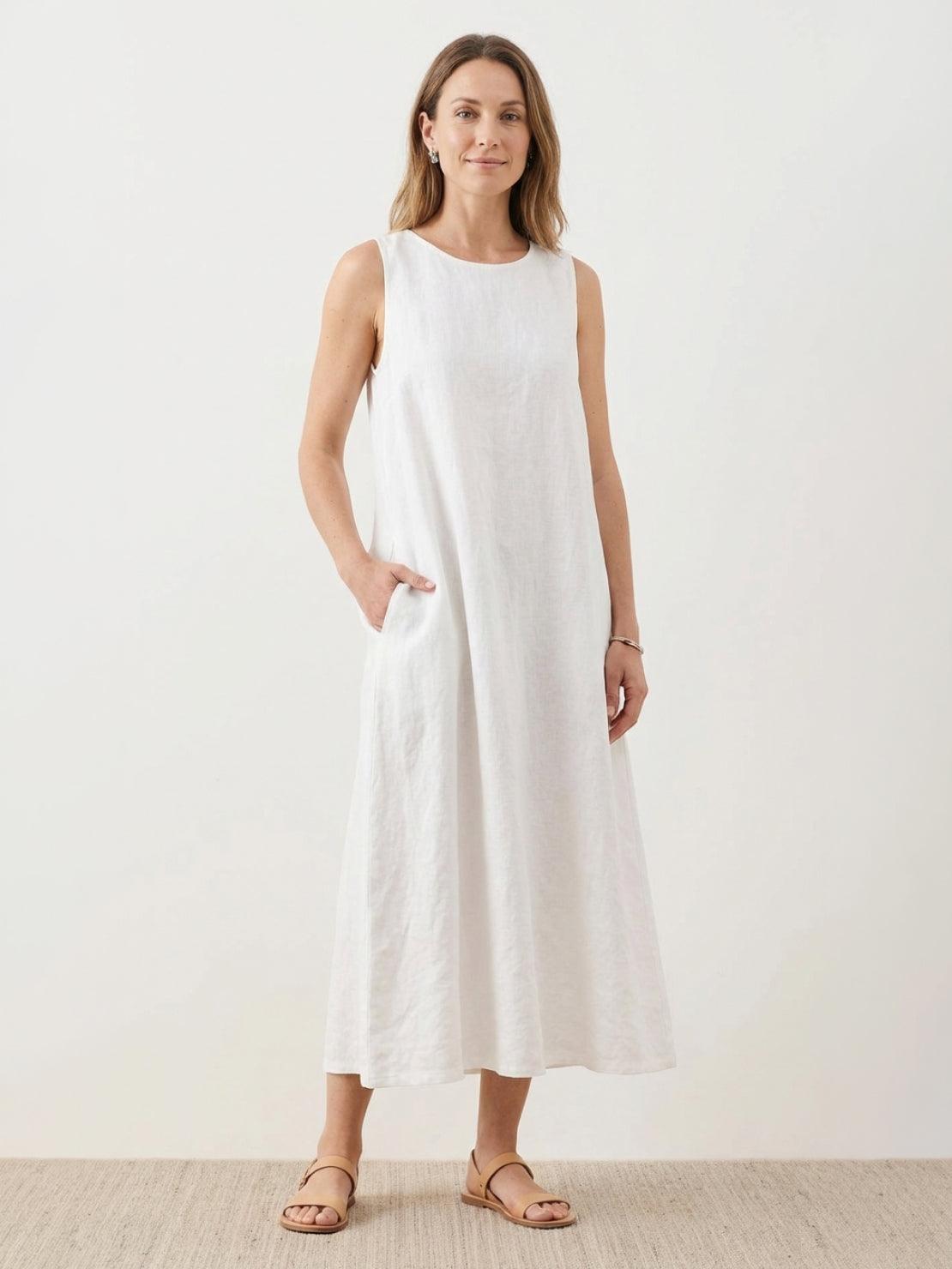 woman wearing 100% cotton linen sleeveless maxi dress with round neckline and loose flowing silhouette reaching ankle