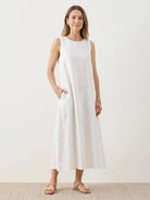 woman wearing 100% cotton linen sleeveless maxi dress with round neckline and loose flowing silhouette reaching ankle