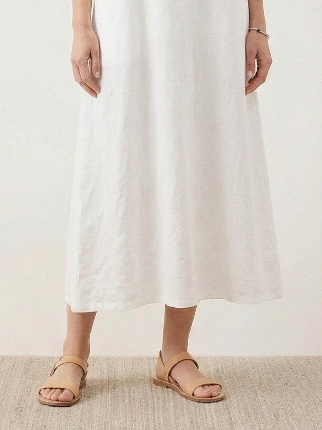 Woman wearing a 100% cotton linen sleeveless maxi dress with round neckline and flowing ankle-length silhouette