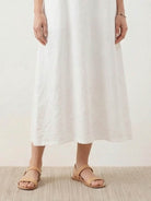 Woman wearing a 100% cotton linen sleeveless maxi dress with round neckline and flowing ankle-length silhouette