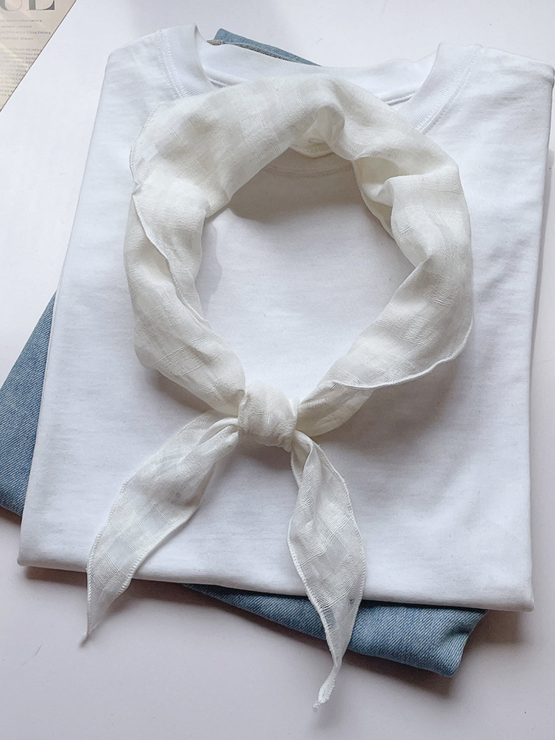 Lightweight 100% linen neck scarf with checkered pattern and natural rolled edges, styled on a white background