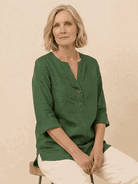 woman wearing pure linen age-defying button detail shirt in white with rolled-up sleeves