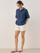 woman wearing 100% linen relaxed V-neck top with asymmetric button detail in cream color