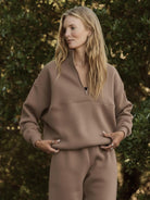 woman wearing cotton-blended two-piece tracksuit with high collar and zipper outdoors