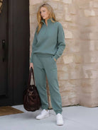Woman wearing a cotton-blended two-piece tracksuit with high collar and deep zipper, showcasing athleisure style and comfort