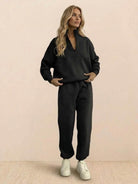 Woman wearing a cotton-blended two-piece tracksuit with high collar and zipper, styled for casual comfort and confident athleisure look